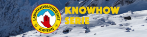 Bild zeigt zwei Wintersportler, die mit Ski einen schneebedeckten Hang runterfahren. Im Hintergrund sind schattige Berghänge zu sehen. In der Bildmitte ist das Logo des Lawinenwarndienstes Bayern und der Text Knowhow Serie zu sehen